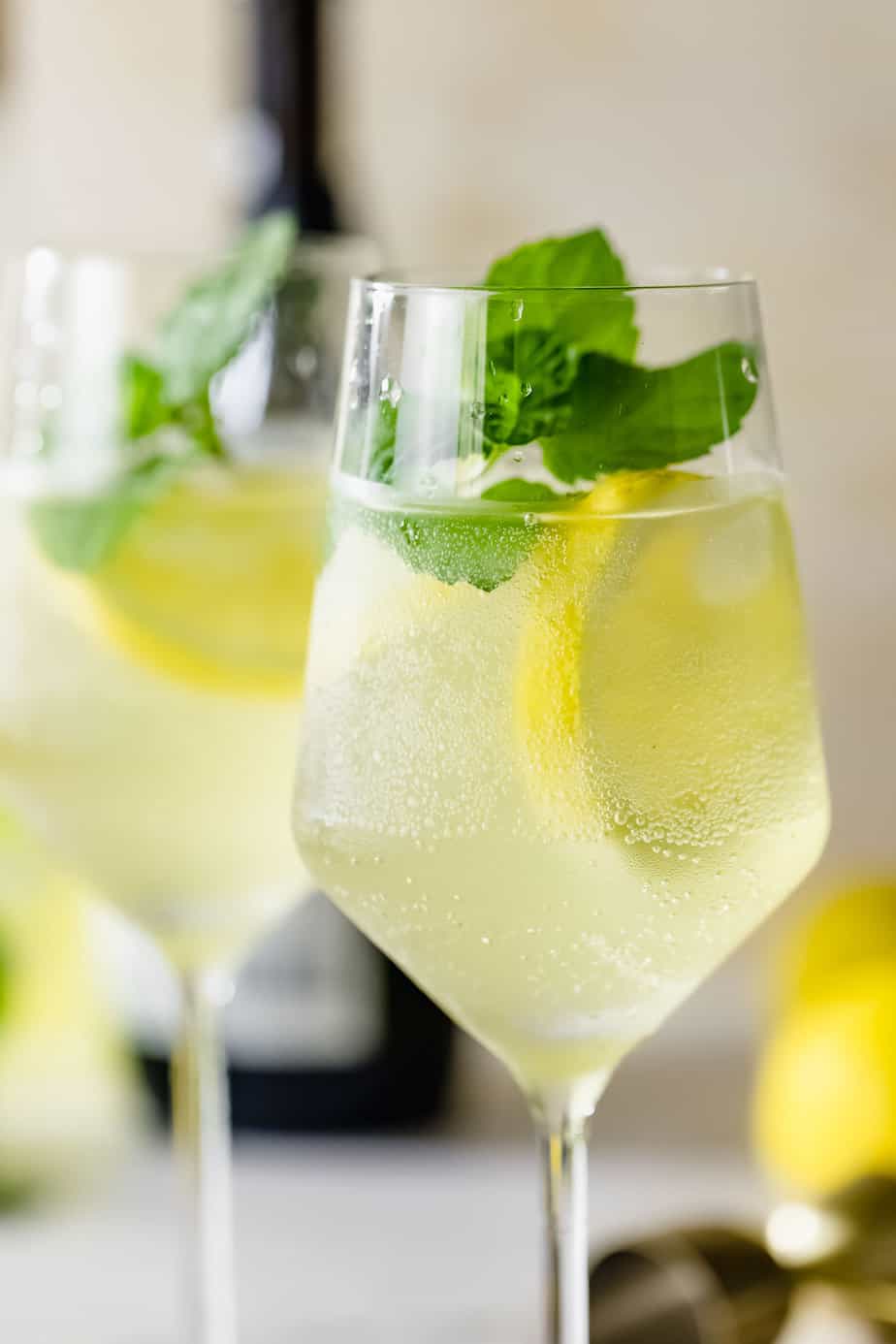 wine glass with fresh lemon slices and mint and limoncello spritz cocktail