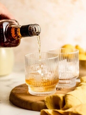 whiskey pouring into ribbed glass over ice