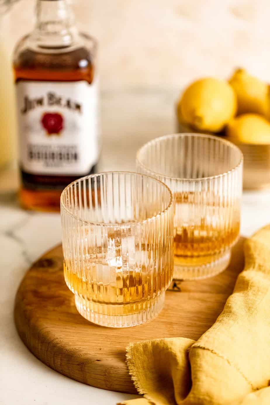 whiskey in two glasses with ice and yellow cloth