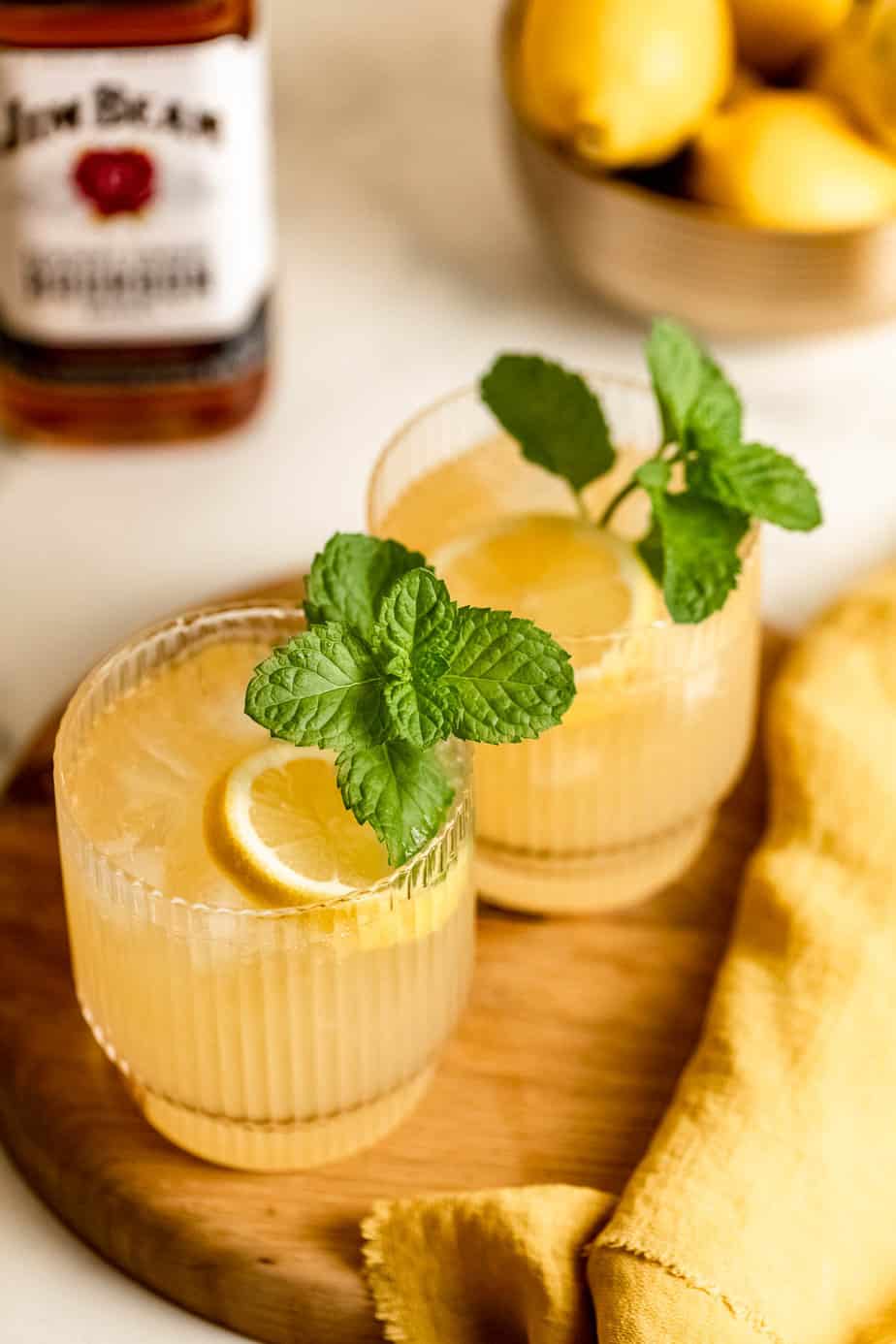 bourbon lemonade on wooden board with fresh mint and lemon