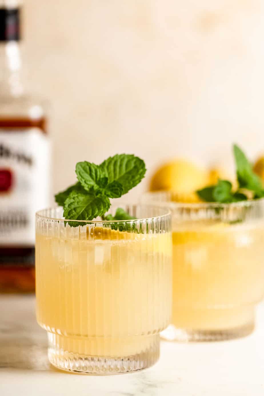 bourbon summer lemonade cocktail in wide ribbed glasses with fresh mint 