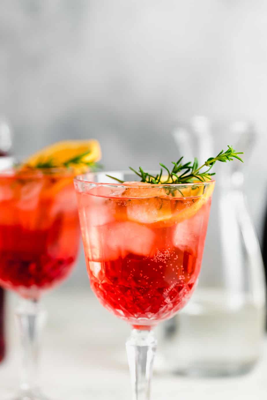 Aperol Spritz served with fresh herbs and oranges.
