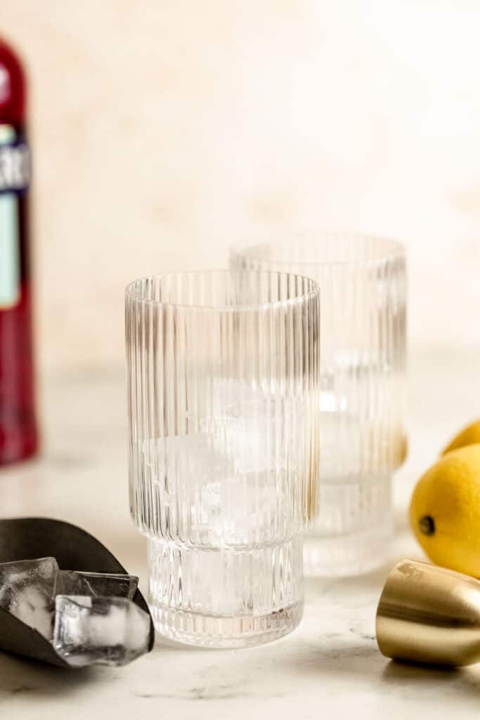 glasses with ice and campari bottle in background