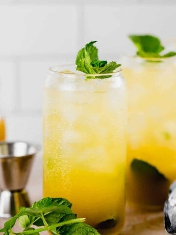 two glasses with mango mojito and fresh mint