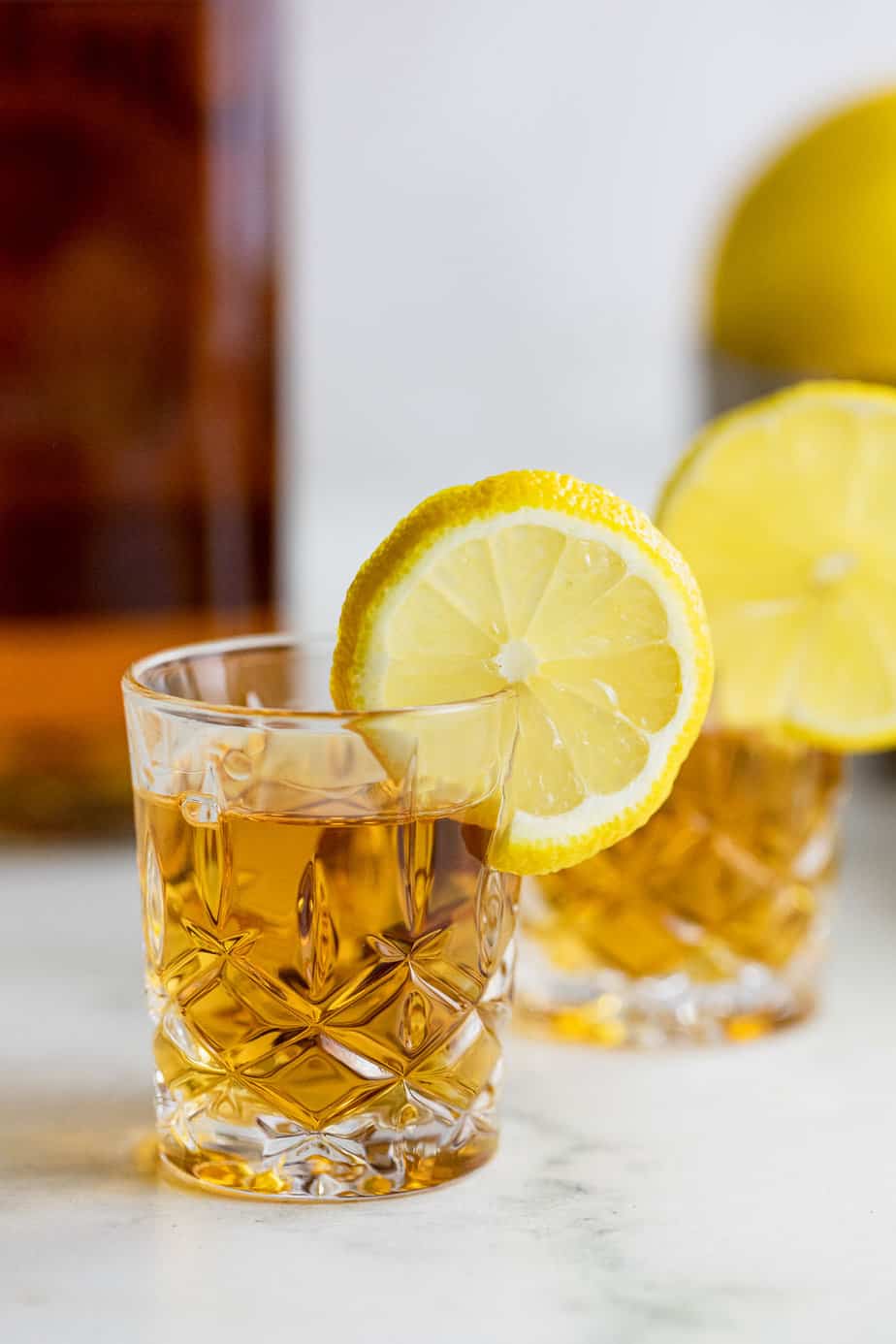 Two whiskey shots with a slice of lemon on each