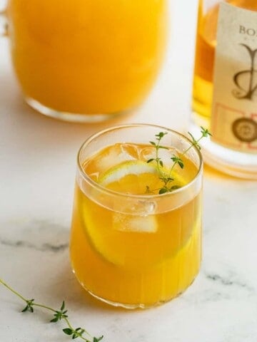 whiskey and orange juice garnished with fresh thyme