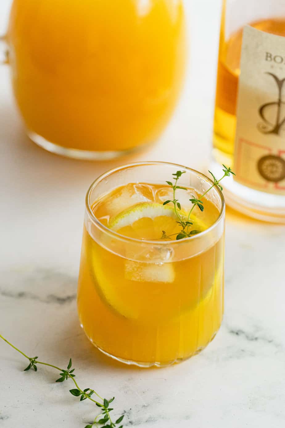 whiskey and orange juice garnished with fresh thyme