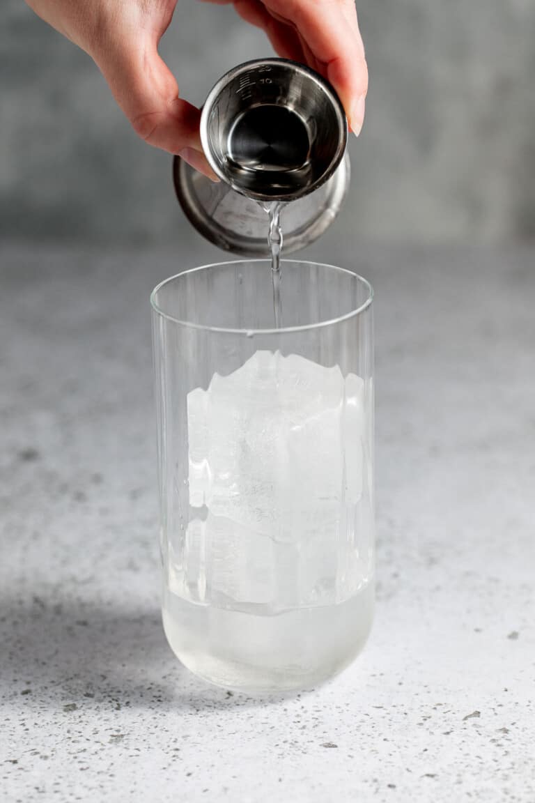 pouring gin into cocktail glass