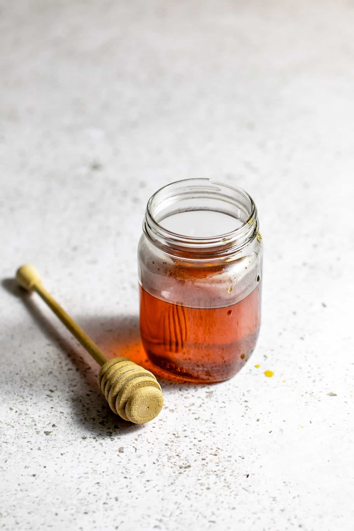 A glass jar filled with a golden-colored syrup.