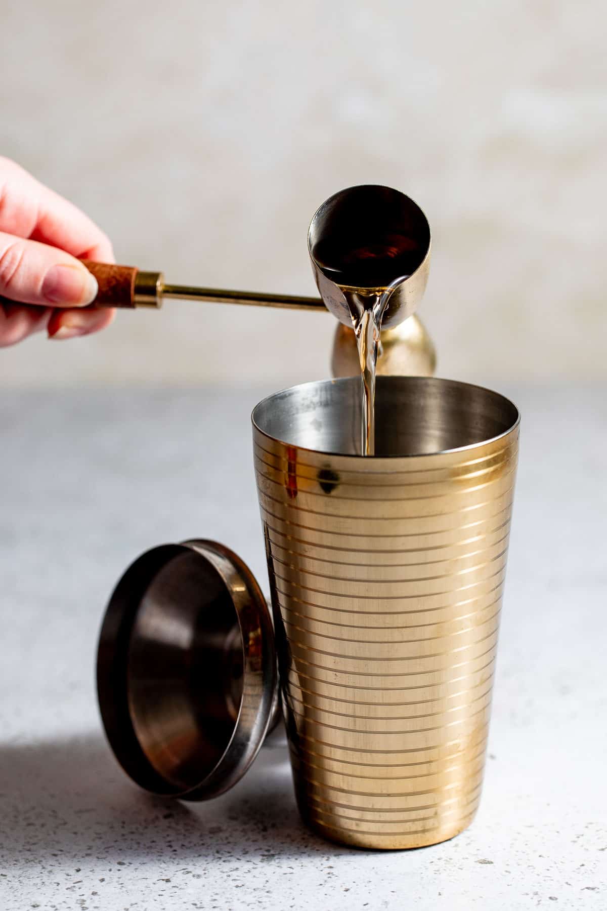 Vermouth pouring into a cocktail shaker
