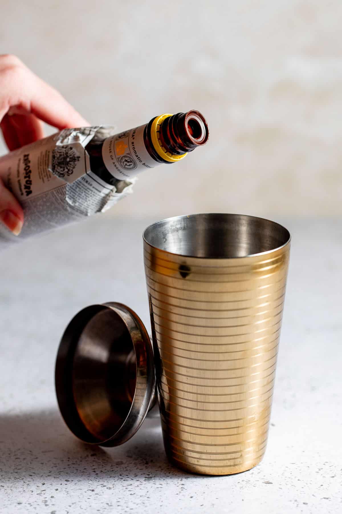 Angostura bitters pouring into a cocktail shaker