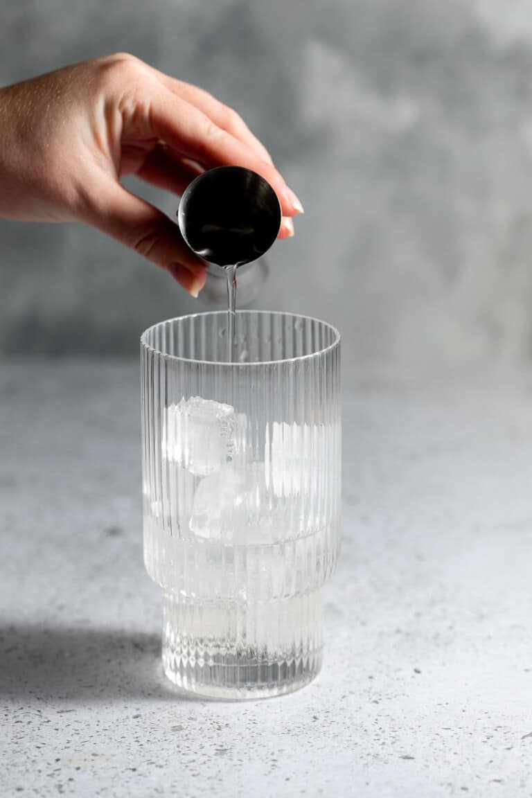 adding vodka to glass with ice