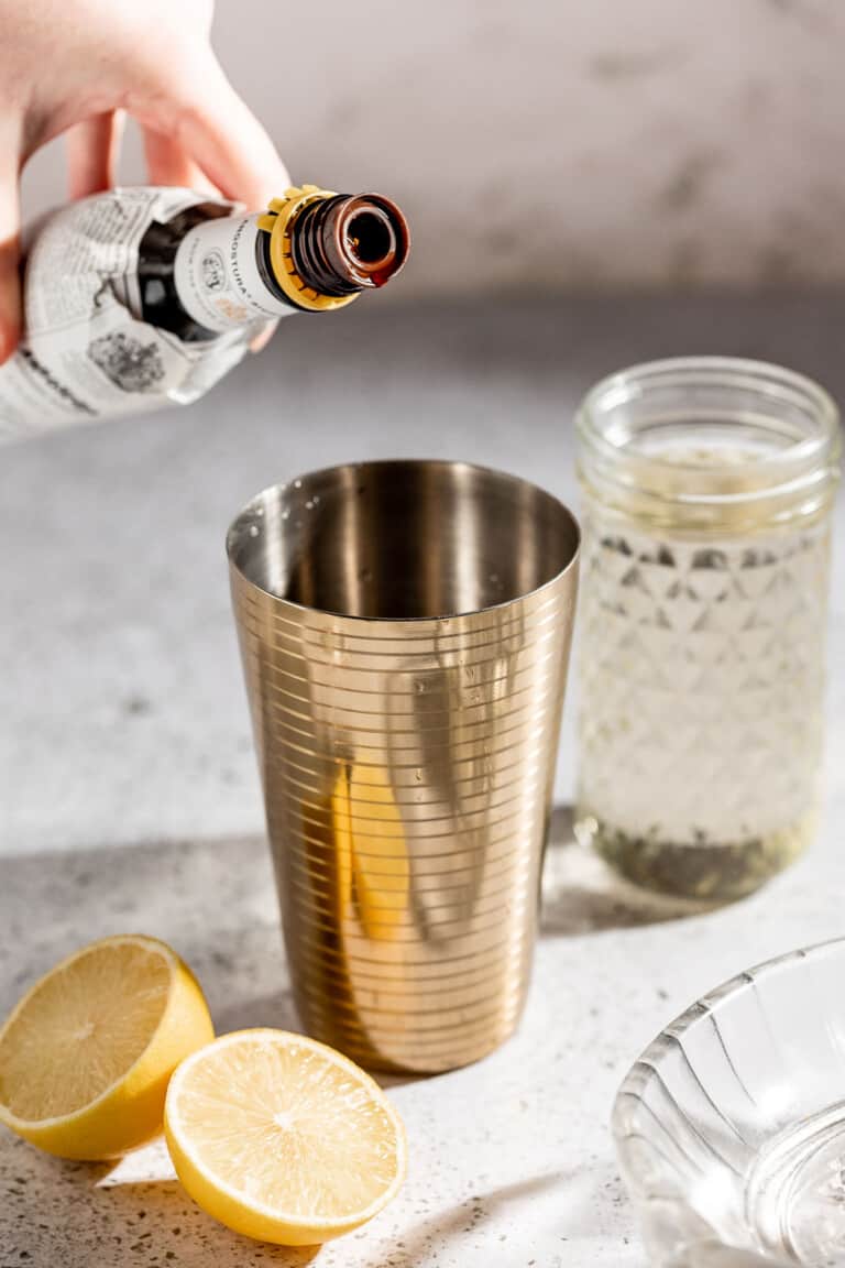 adding bitters to cocktail shaker