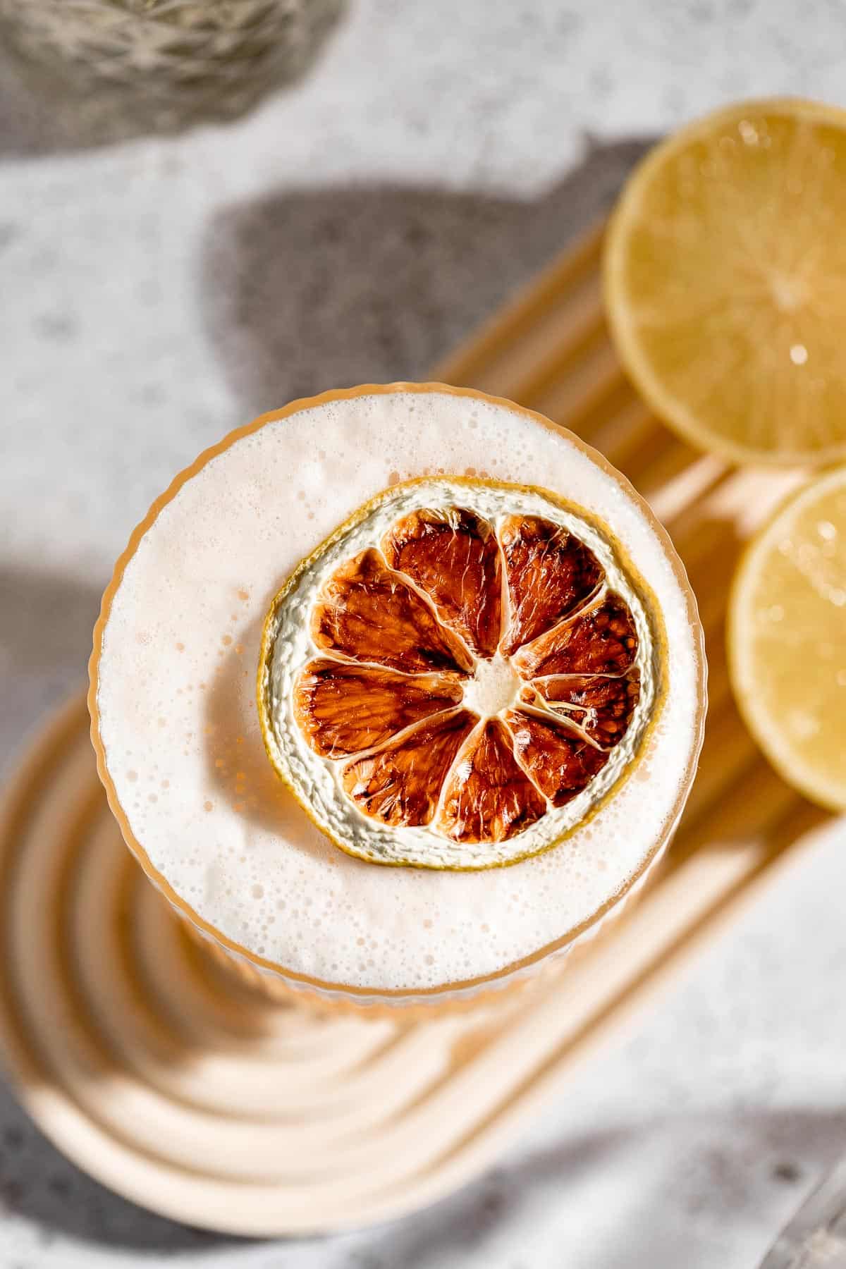 vodka sour on background with fresh lemon halves