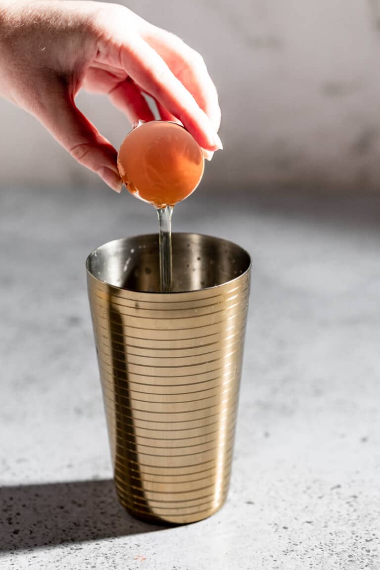 pouring egg white into cocktail shaker