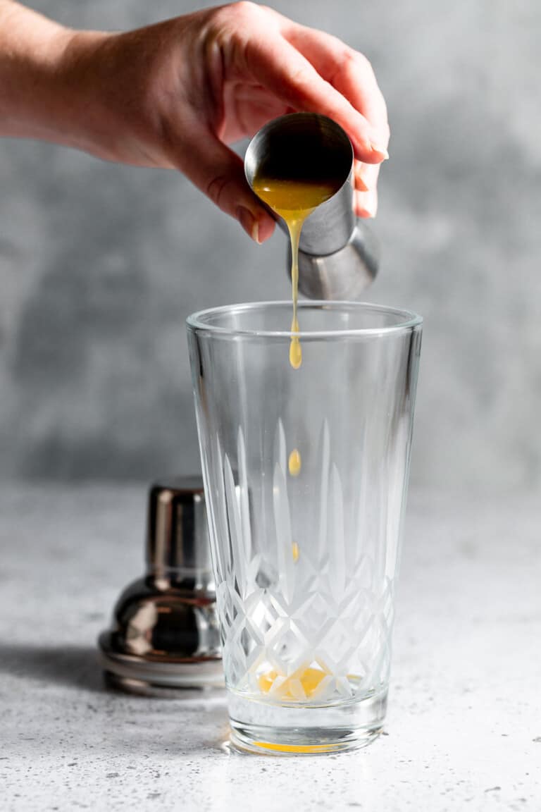 pouring passionfruit pulp into cocktail shaker