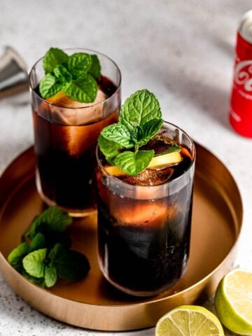 vodka and coke in tall glasses topped with fresh mint