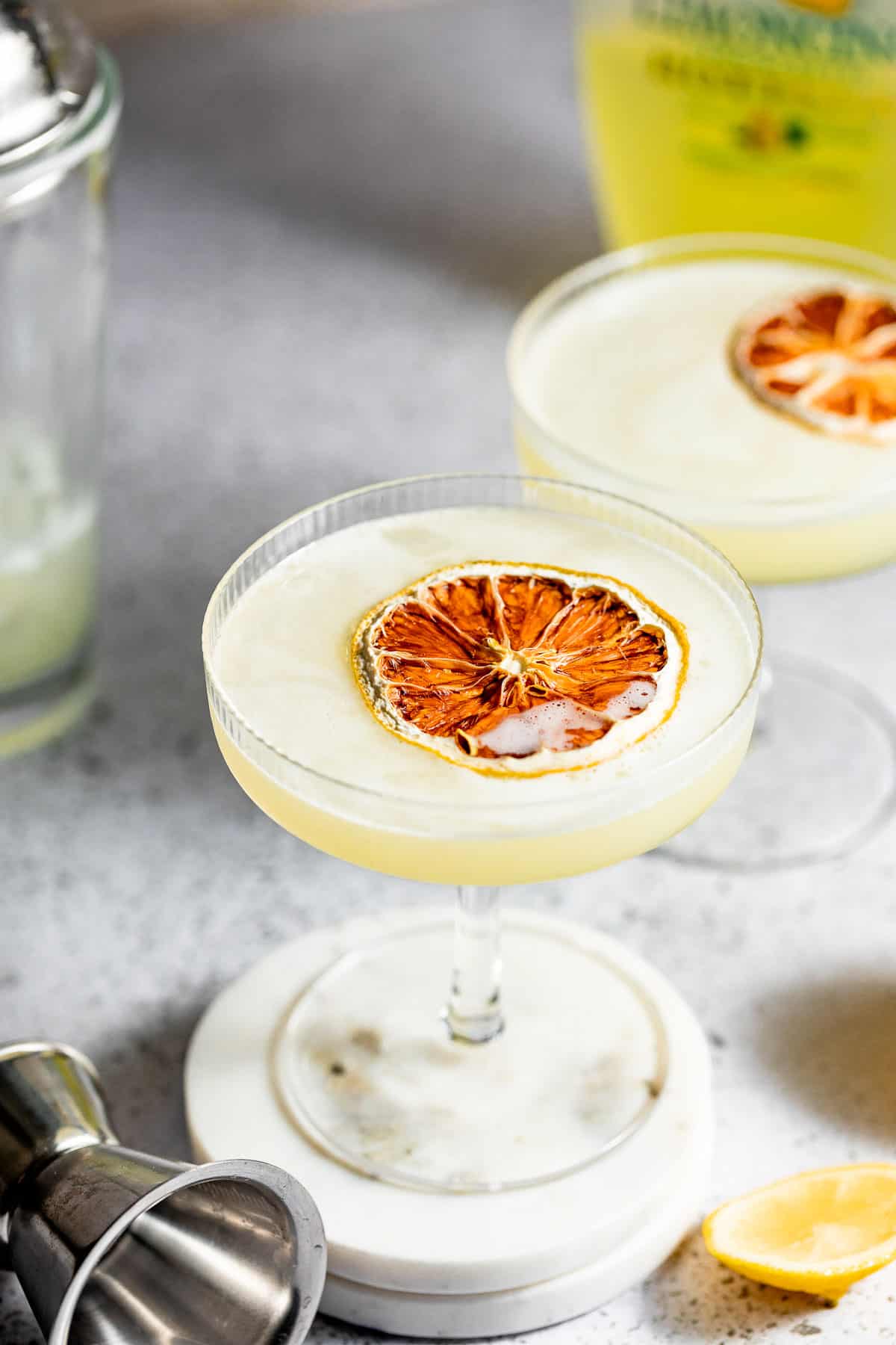 limoncello martini in tall glasses with bottle of limoncello in the background