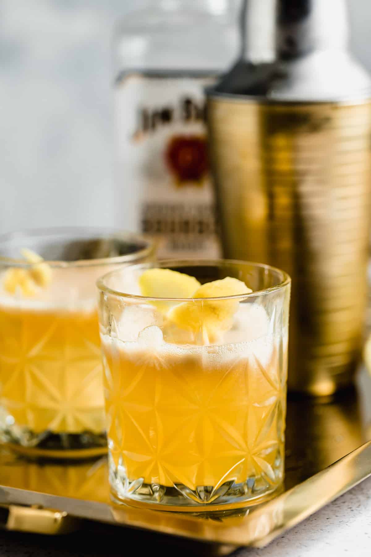 A gold rush cocktail with ice in a serving glass.