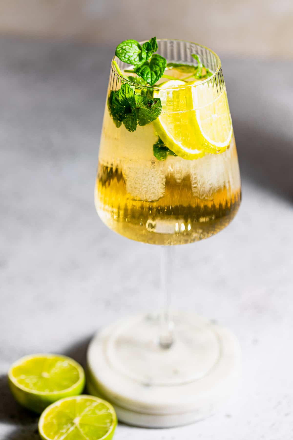 hugo spritz cocktail in tall wine glass with fresh mint and lemon