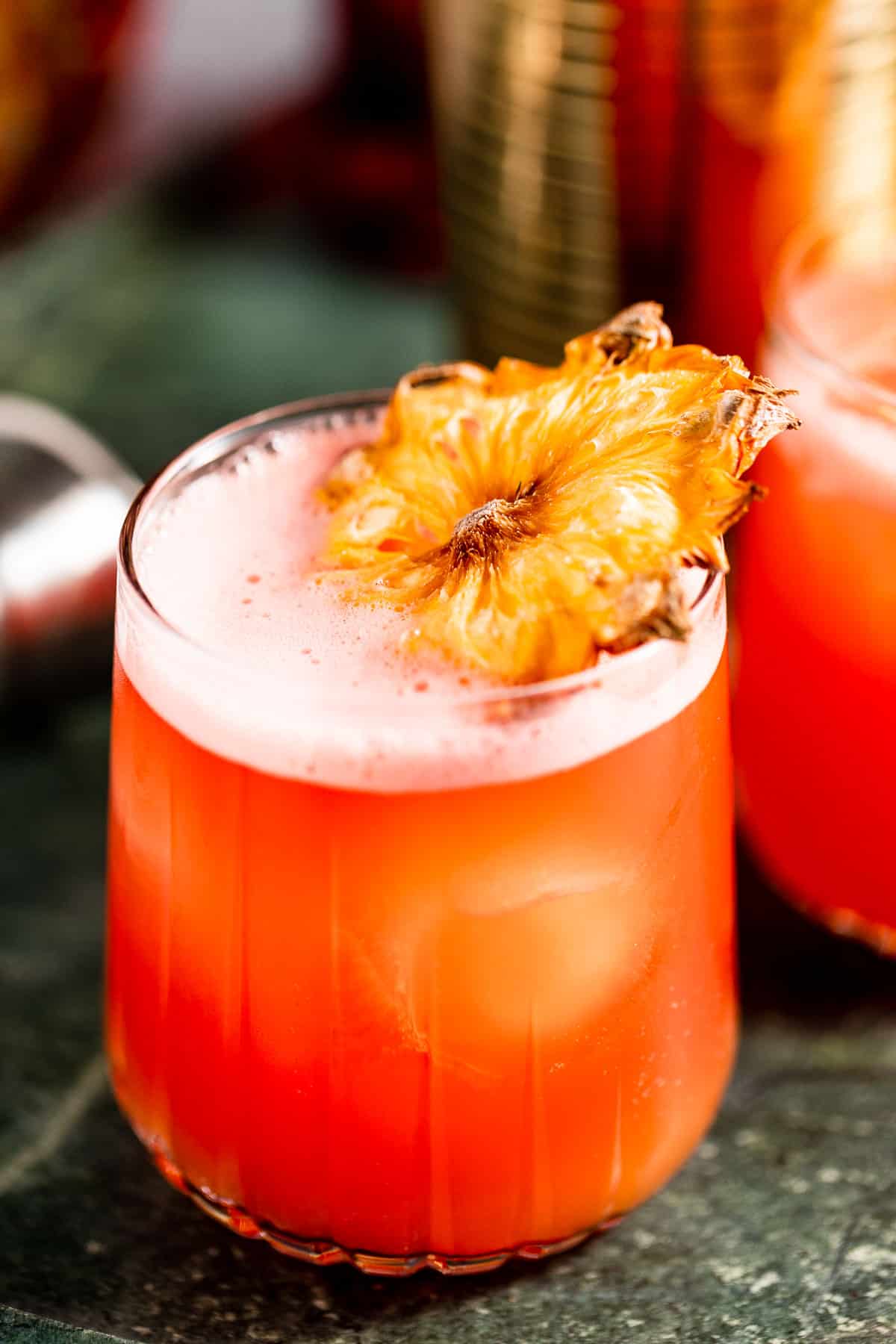 orange cocktail in glass with dried pineapple slice