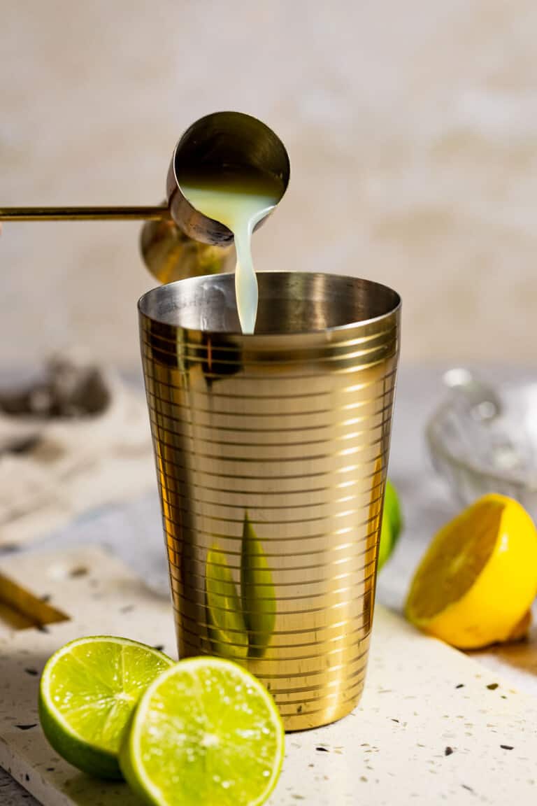 adding lemon juice to cocktail shaker