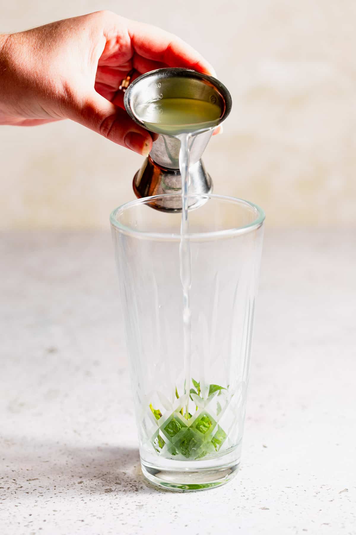 Lime juice pouring into a glass drink shaker