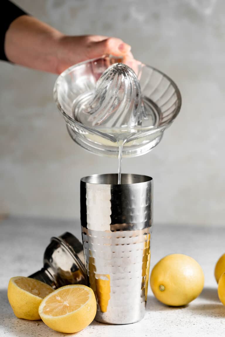 pouring lemon juice into cocktail shaker