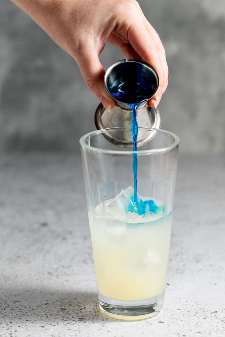 adding blue caracauo into cocktail shaker