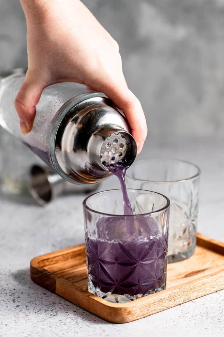 pouring cocktail into glass over ice