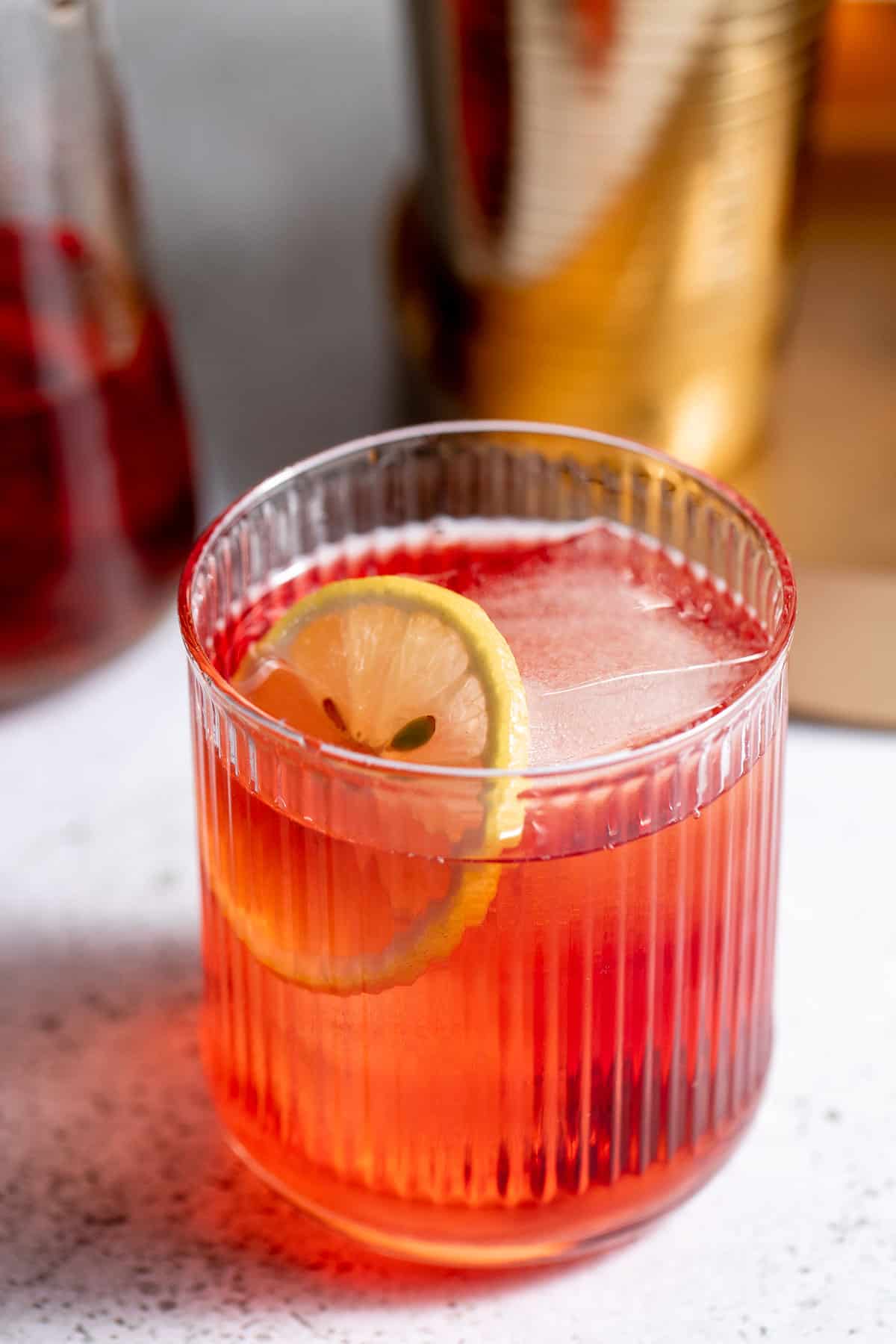 tumbler glass with royal flush cocktail and fresh lemon slice