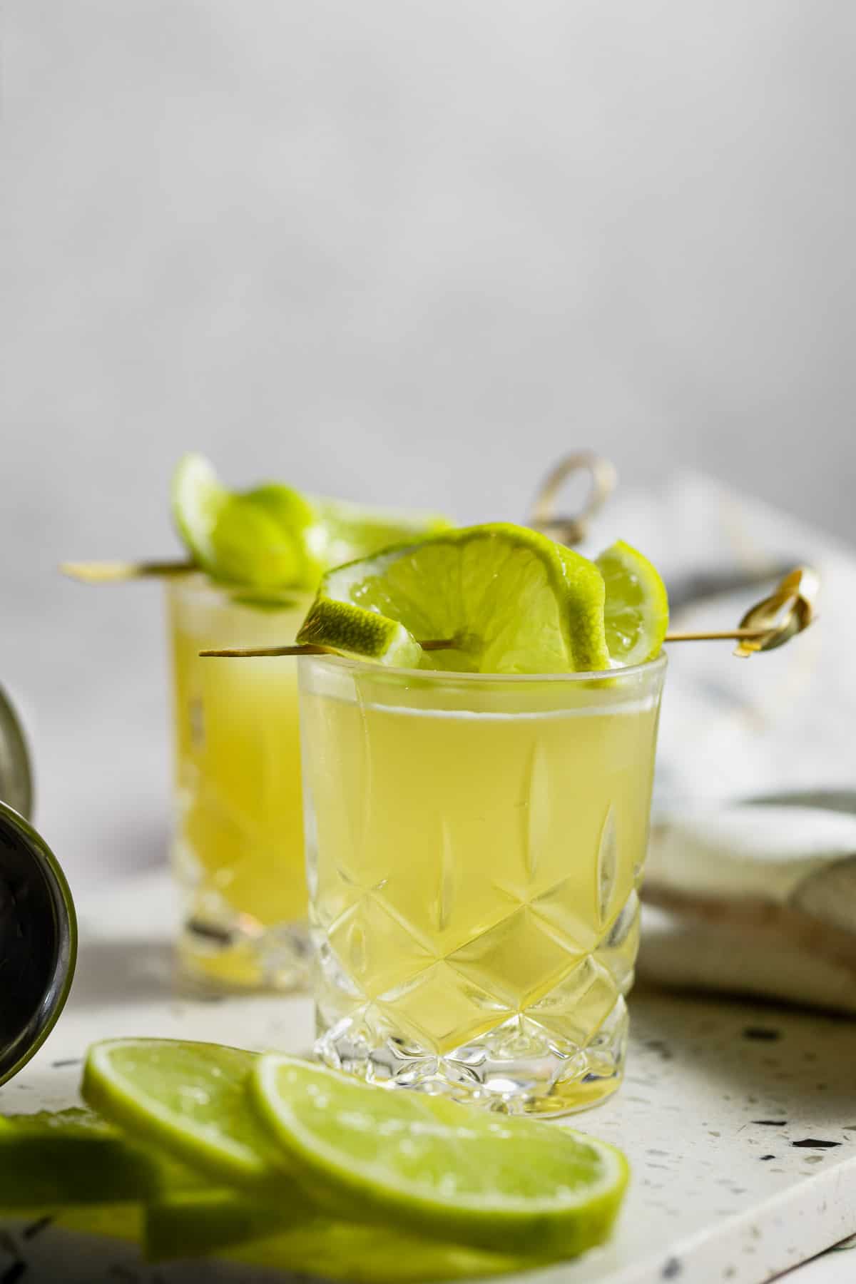 two shot glasses topped with lime slices