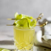 green tea shot garnished with lime slices